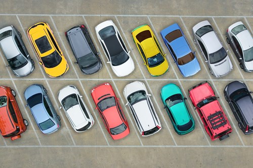 Aerial view of a parking lot showing two rows of colorful cars