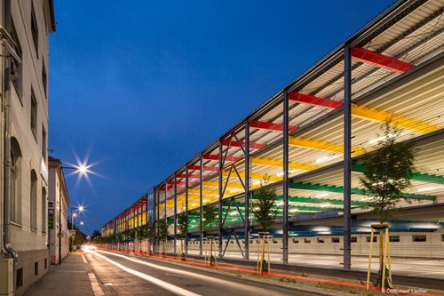 Multi-storey, open metal parking garage with rainbow colored layers